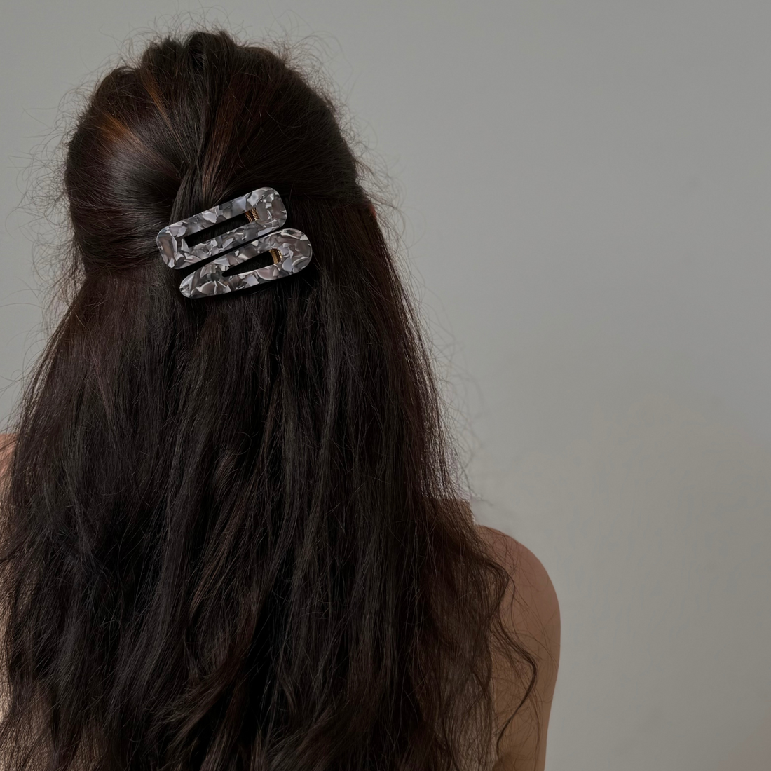 Woman wearing acetate hairclips in long wavy brunette hair