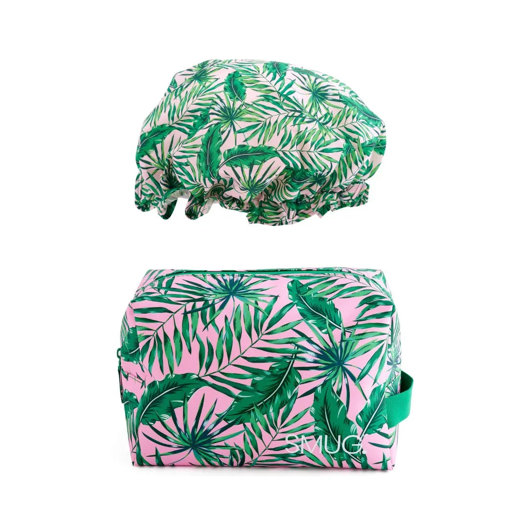 Palm leaf print shower cap and matching toiletry bag set on white background